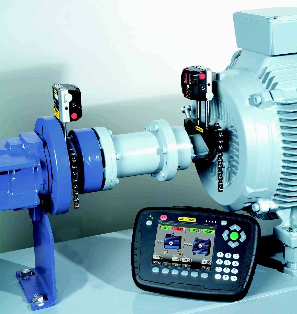 Equipamento de alinhamento a laser instalado entre motor e bomba, com o medidor em primeiro plano
