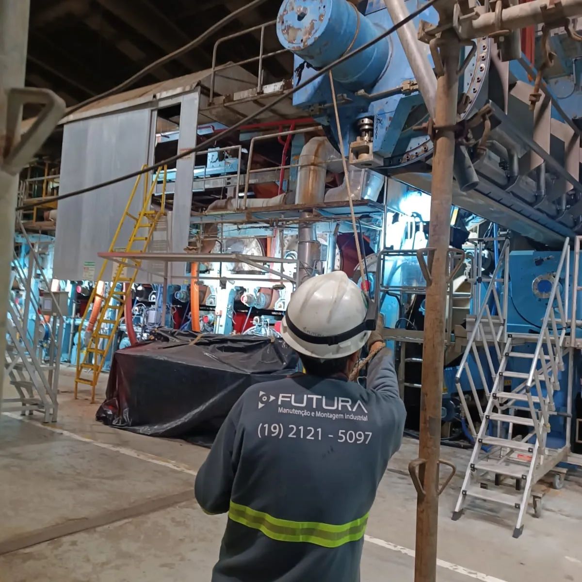 Técnico da Futura em frente a uma máquina industrial de grande porte