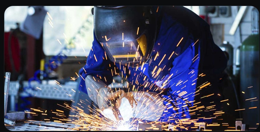 Soldador trabalhando com faíscas em uma oficina
